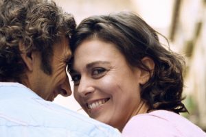 Couple standing outdoors, smiling, portrait